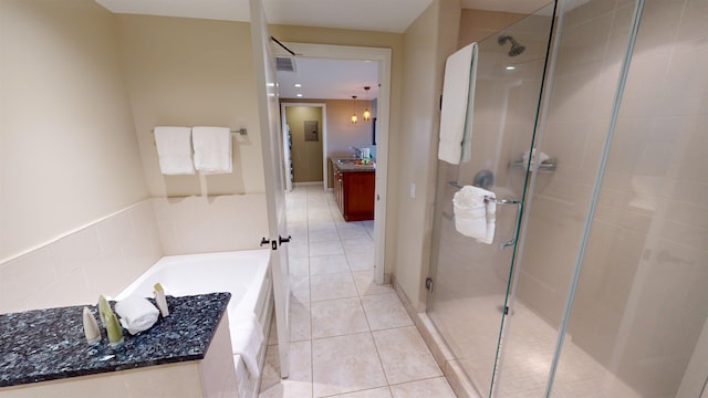 bathroom featuring tile patterned floors, vanity, and shower with separate bathtub