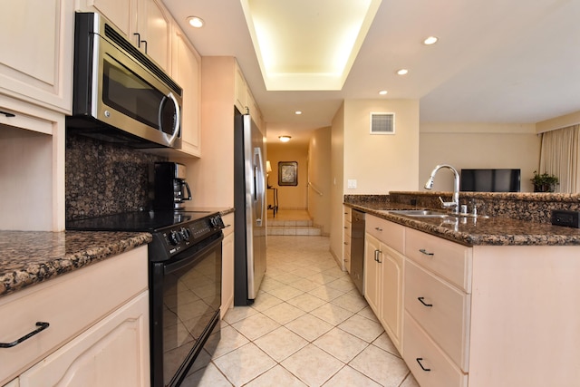 kitchen with stainless steel appliances, sink, light tile floors, tasteful backsplash, and dark stone counters