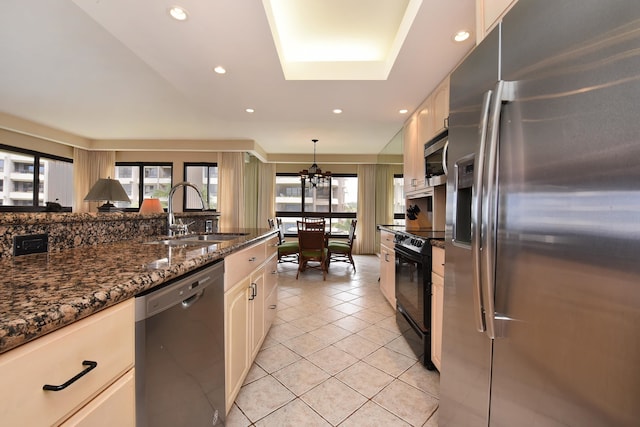 kitchen featuring appliances with stainless steel finishes, white cabinets, sink, light tile flooring, and pendant lighting