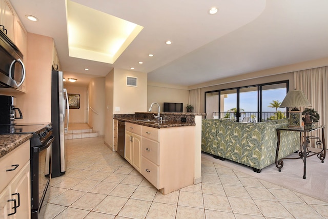 kitchen with white cabinets, stainless steel appliances, light tile floors, sink, and dark stone countertops