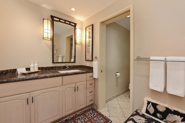 bathroom with tile flooring, oversized vanity, and toilet