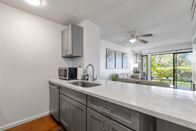 kitchen with stainless steel appliances, ceiling fan, dark wood-type flooring, sink, and gray cabinets