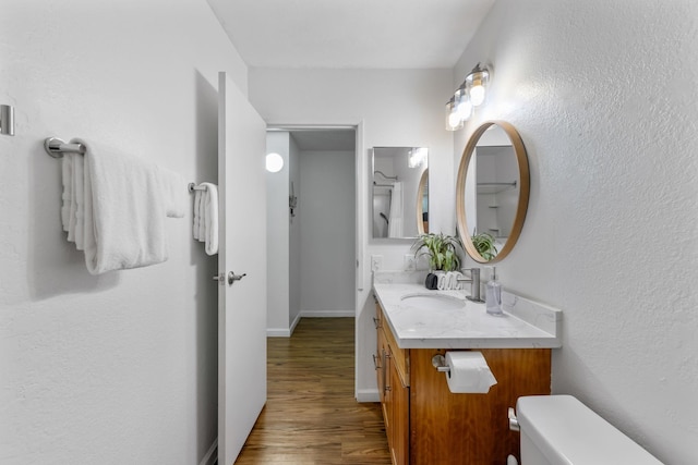 bathroom featuring vanity, hardwood / wood-style flooring, and toilet