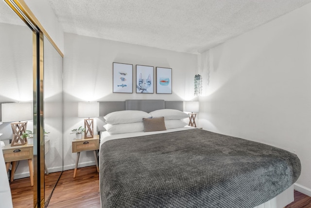 bedroom featuring a closet, hardwood / wood-style floors, and a textured ceiling