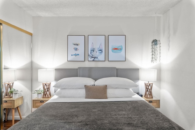 bedroom featuring wood-type flooring and a textured ceiling