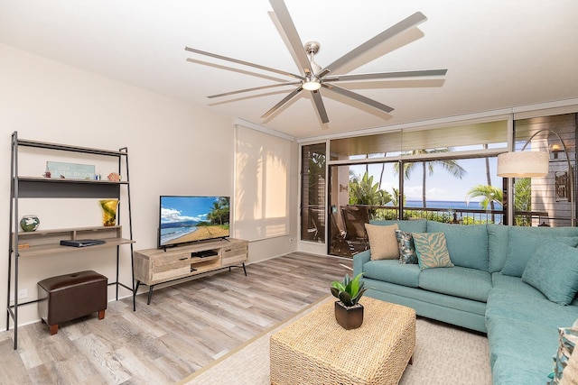 living room with ceiling fan, floor to ceiling windows, and light hardwood / wood-style flooring