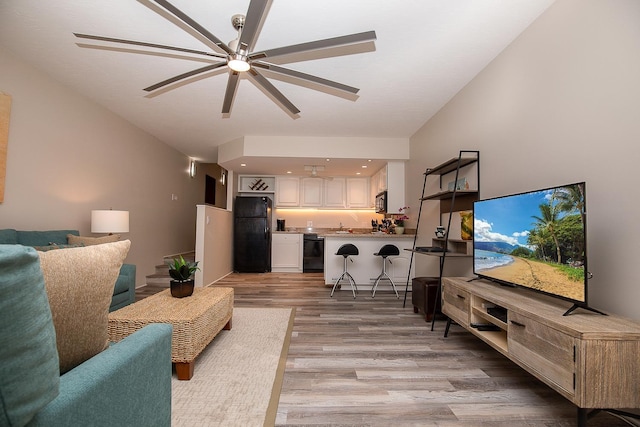 living room featuring ceiling fan and light hardwood / wood-style flooring