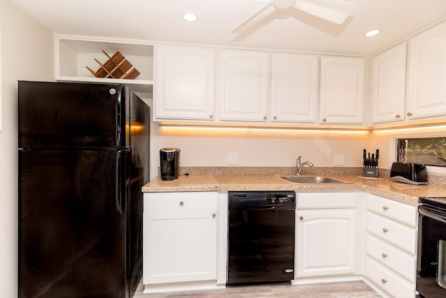 kitchen featuring sink, light hardwood / wood-style floors, white cabinets, and black appliances