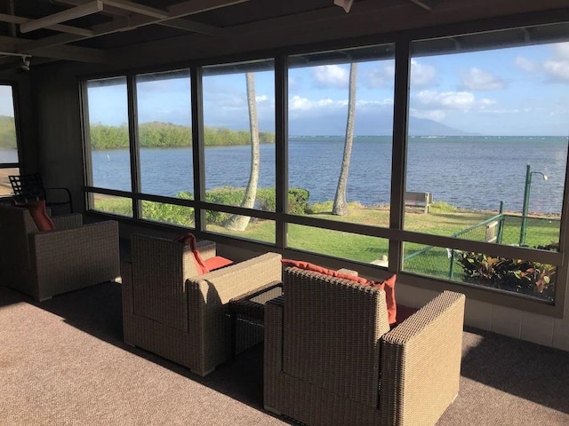 sunroom featuring a water view