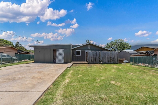 view of front facade with an outdoor structure, a front lawn, and a carport