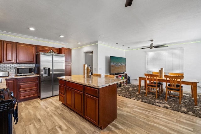 kitchen with ceiling fan, appliances with stainless steel finishes, ornamental molding, and light wood-type flooring