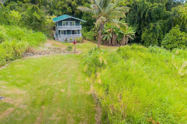 view of yard featuring a balcony and a porch