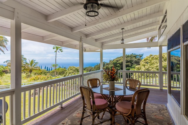 sunroom with wood finished floors, a wooden deck, a ceiling fan, wood ceiling, and outdoor dining area