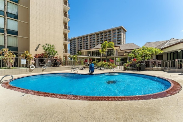 community pool featuring fence and a patio