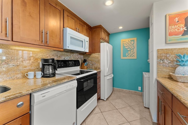 kitchen featuring light stone counters, light tile patterned flooring, white appliances, tasteful backsplash, and brown cabinetry