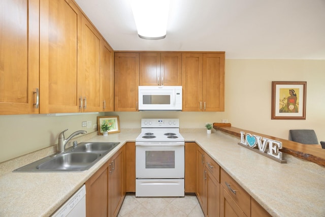 kitchen featuring white appliances, light countertops, and a sink