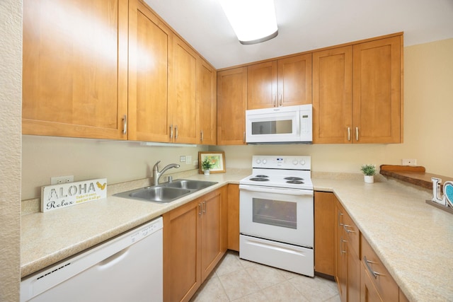 kitchen featuring brown cabinets, white appliances, light countertops, and a sink