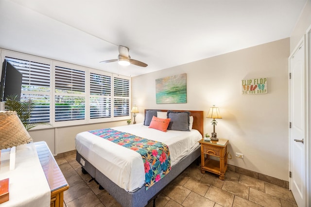 bedroom featuring baseboards and ceiling fan