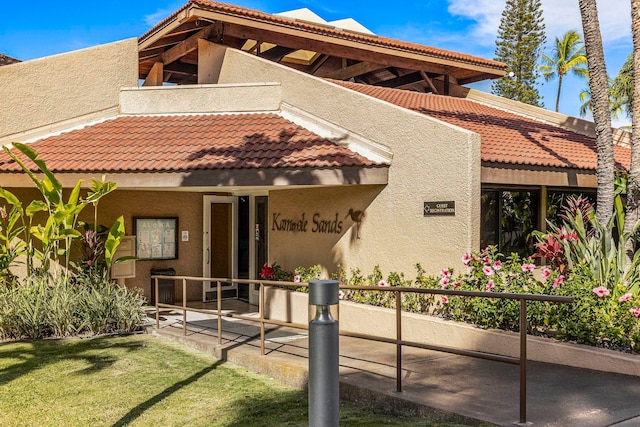 view of front of property featuring stucco siding, a balcony, and a tiled roof