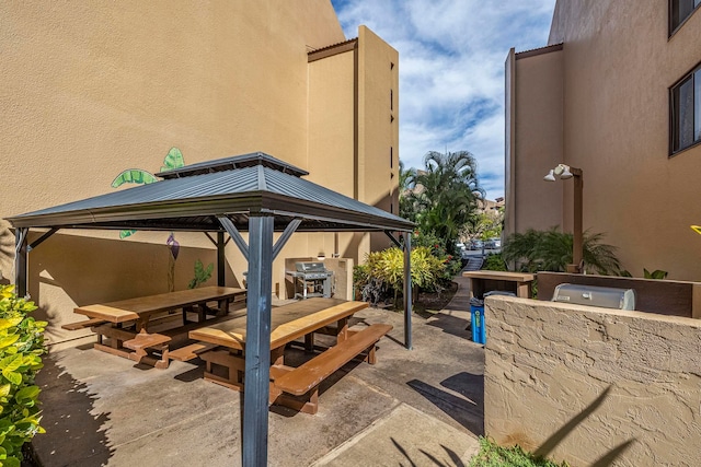 view of patio / terrace featuring a gazebo, grilling area, exterior kitchen, and outdoor dining area