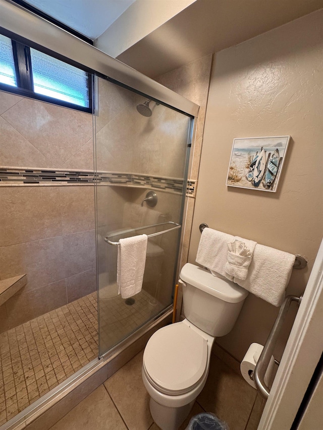 full bath with a shower stall, tile patterned floors, and toilet