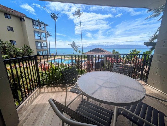 wooden terrace with outdoor dining space and a water view
