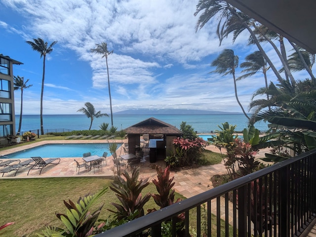 view of pool with a patio and a water view