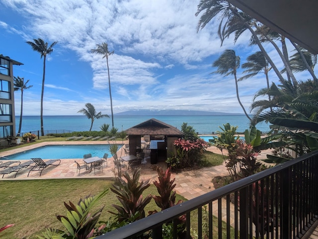 community pool featuring a water view, a yard, and a patio area