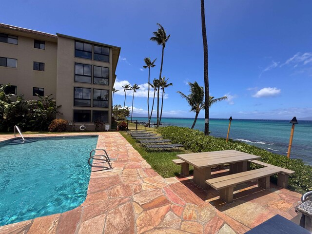 view of swimming pool with a patio and a water view