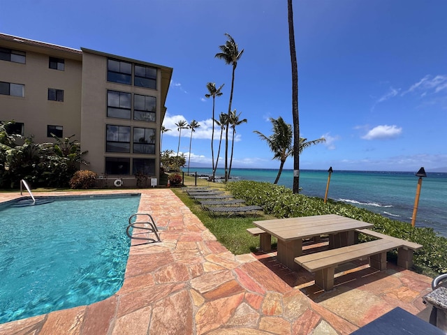 pool featuring a water view and a patio