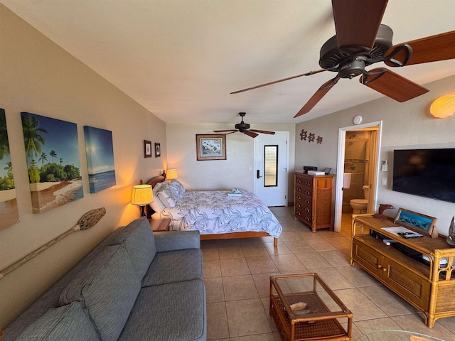 bedroom with a ceiling fan, light tile patterned floors, and connected bathroom
