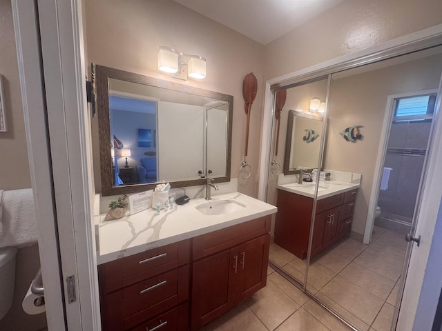 full bathroom with a sink, toilet, tile patterned floors, and two vanities