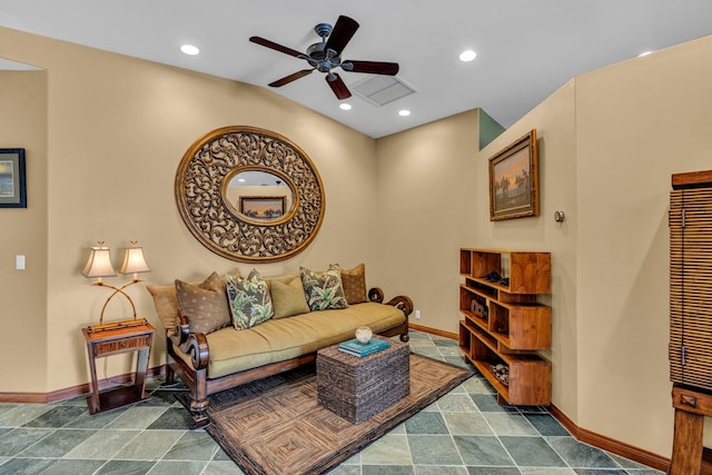 living room with visible vents, baseboards, stone finish floor, and ceiling fan