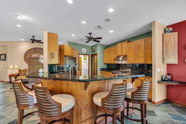 kitchen with under cabinet range hood, visible vents, ceiling fan, and stainless steel appliances