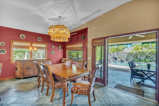 dining area with vaulted ceiling, stone tile floors, baseboards, and a notable chandelier