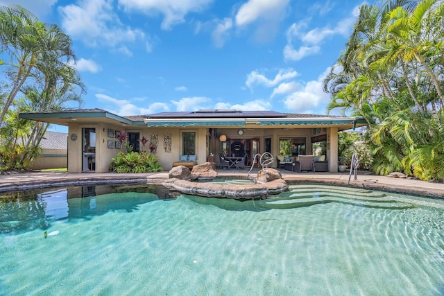 pool featuring a patio and an in ground hot tub
