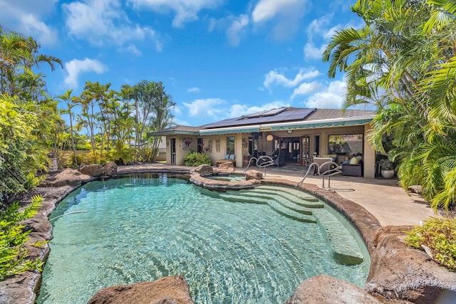 view of pool featuring a pool with connected hot tub, a patio area, and ceiling fan