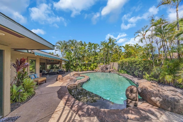 view of swimming pool featuring a fenced backyard, outdoor lounge area, a pool with connected hot tub, and a patio