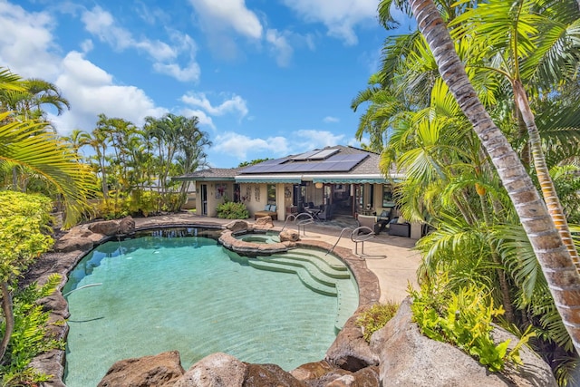 view of swimming pool with a patio and a pool with connected hot tub