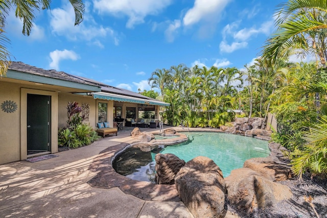 outdoor pool with a patio and an in ground hot tub