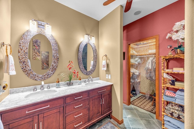 bathroom with a ceiling fan, a sink, double vanity, and a stall shower