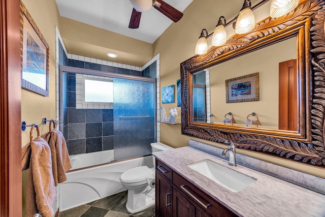 bathroom with toilet, a ceiling fan, vanity, and bath / shower combo with glass door