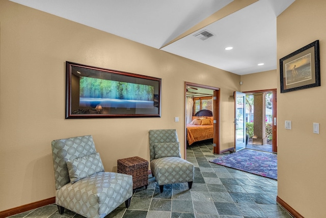 sitting room with baseboards, stone finish floor, visible vents, and recessed lighting