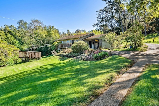 view of front facade with a deck and a front lawn