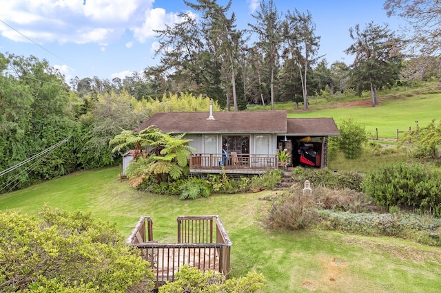 back of house featuring a lawn and a wooden deck