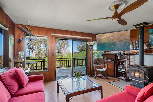 interior space featuring ceiling fan and a wood stove