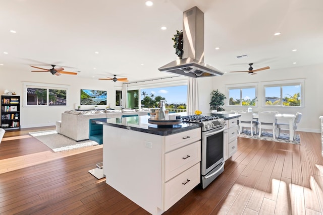 kitchen featuring a kitchen island, white cabinetry, dark hardwood / wood-style flooring, island range hood, and stainless steel range with gas stovetop