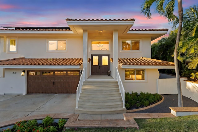 mediterranean / spanish home with a garage and solar panels