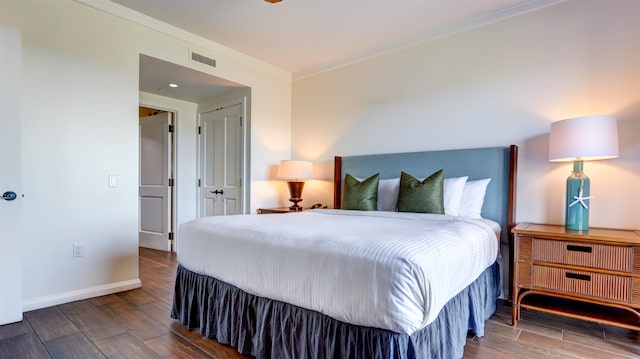 bedroom featuring ornamental molding, dark hardwood / wood-style floors, and a closet