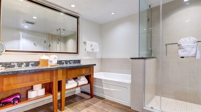 bathroom featuring wood-type flooring, separate shower and tub, and vanity